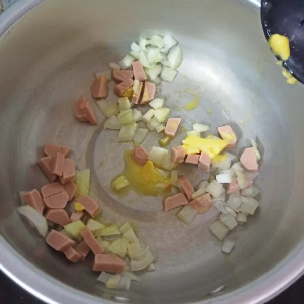Tumis bawang putih hingga harum. 
Masukkan sosis dan bawang bombay, tunggu hingga layu.