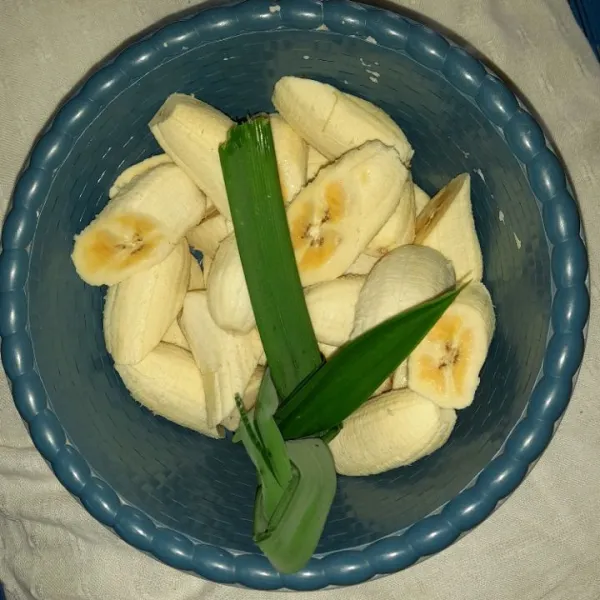 Menunggu sagu mutiara mengembang potong-potong pisang dan simpulkan daun pandan.