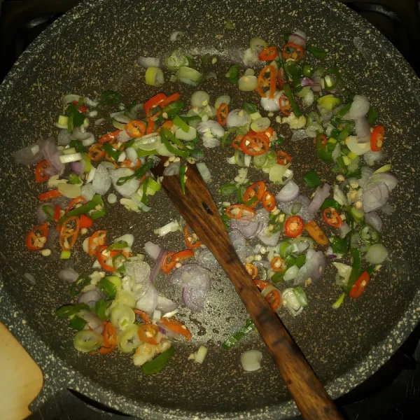 Panaskan minyak, tumis bawang putih, bawang merah, cabe rawit dan daun bawang sampai layu.