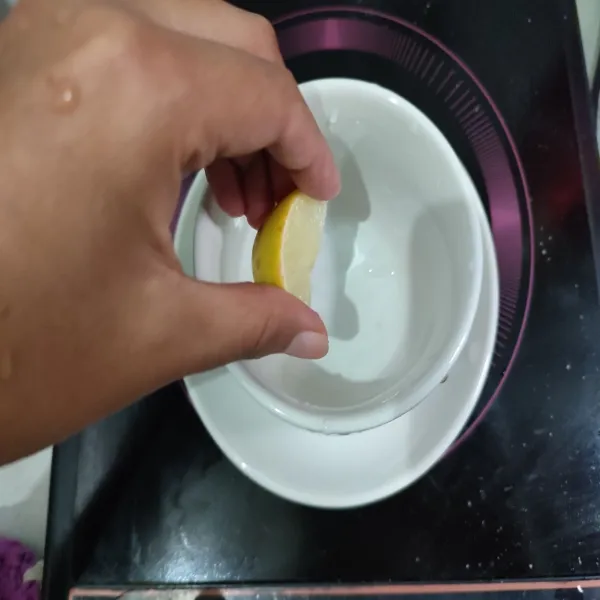 Peras jeruk lemon ke dalam gelas saji yang lain.