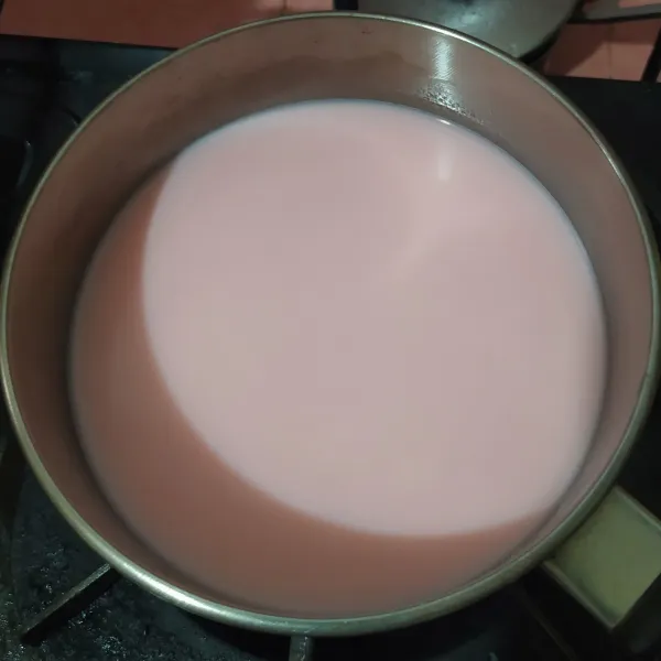 Masukkan susu bubuk, aduk rata sampai mendidih. 
Beri 1 tetes essence strawberry.