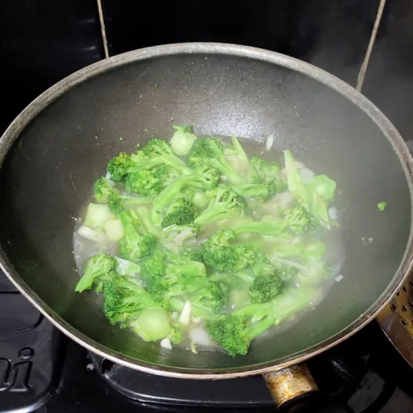 Tumis bawang putih hingga harum lalu masukkan brokoli dan beri sedikit air, masak hingga setengah matang, angkat dan sisihkan.