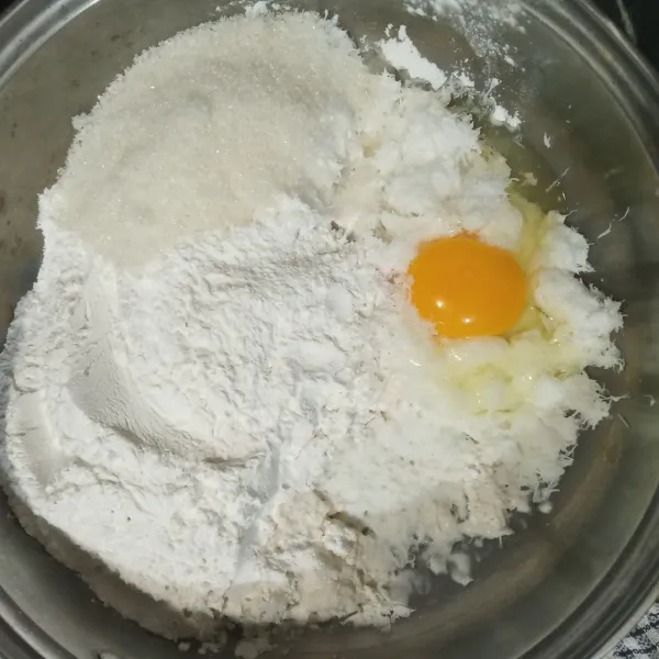 Campurkan kelapa parut, tepung ketan, telur, gula pasir, garam dan vanili bubuk. Aduk.