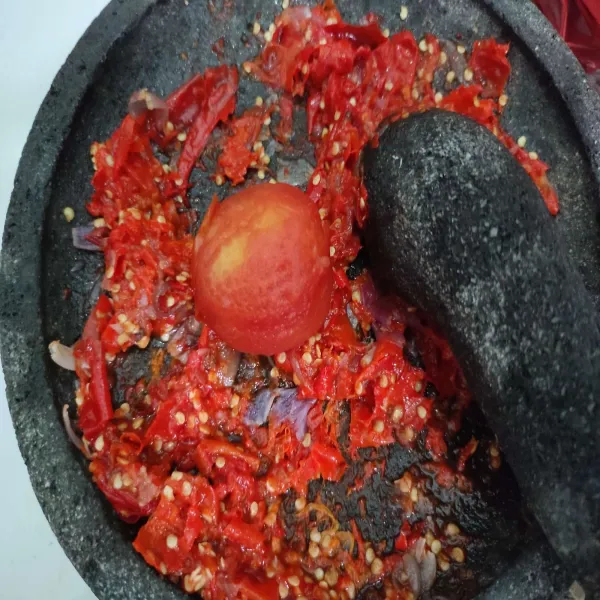 Kemudian beri tomat, ulek kembali hingga tercampur rata.