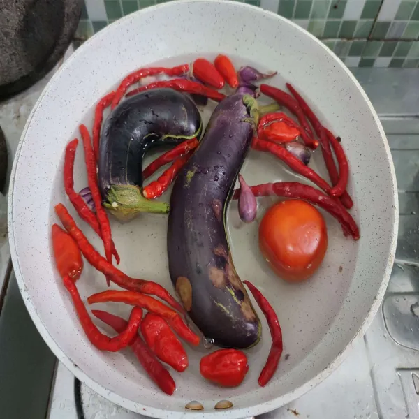 Rebus terong bersama tomat, cabe serta bawang. Biarkan mendidih