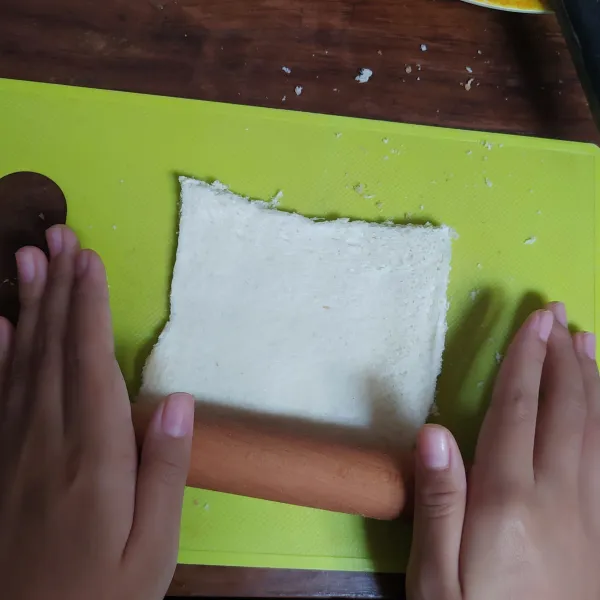 Gilas roti tawar dengan rolling pin.