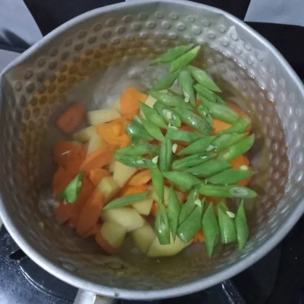 Didihkan air lalu masukkan buncis, wortel dan kentang. Masak hingga setengah empuk.