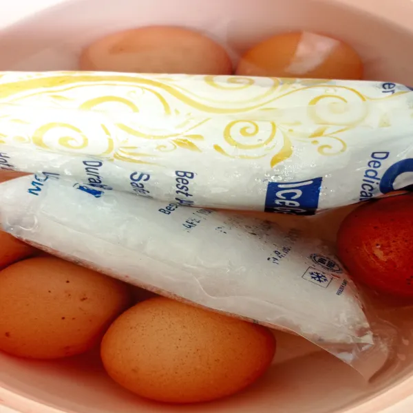 Angkat telur dan masukkan pada wadah berisi air dingin (air matang + es batu) lalu rendam telur hingga cukup dingin kemudian kupas secara hati-hati karena telur agak lembut