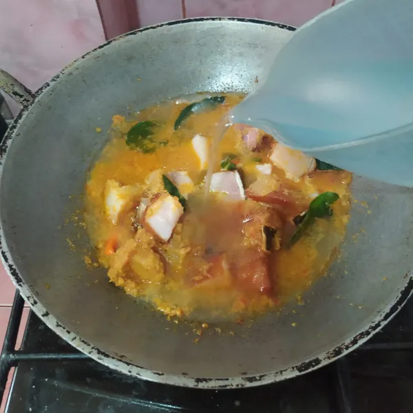 Masukkan iwak pe, tumis sebentar lalu tuang air. 
Masak dengan api kecil supaya bumbu meresap.