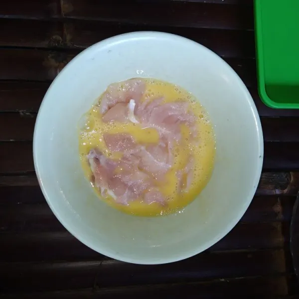 Kocok lepas telur, bumbui dengan garam dan merica, marinasi ayam selama 10 menit.