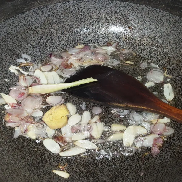Tumis bawang merah dan bawang putih hingga layu, kemudian tambahkan serai dan juga jahe.
