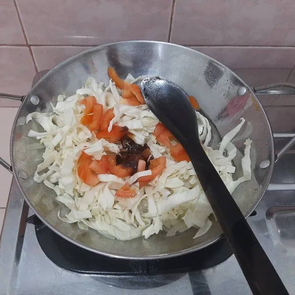 Lalu masukkan kubis, beri air secukupnya dan masukkan tomat dan saus tiram, aduk hingga rata.