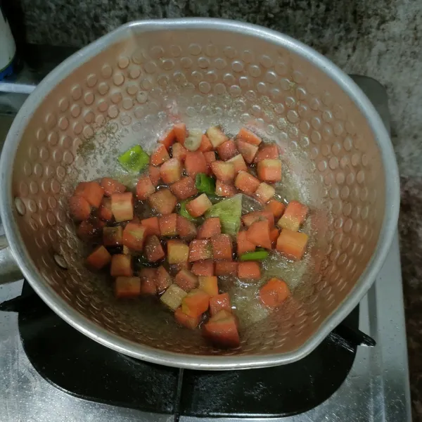 Masukkan potongan wortel, aduk sampai wortel layu.