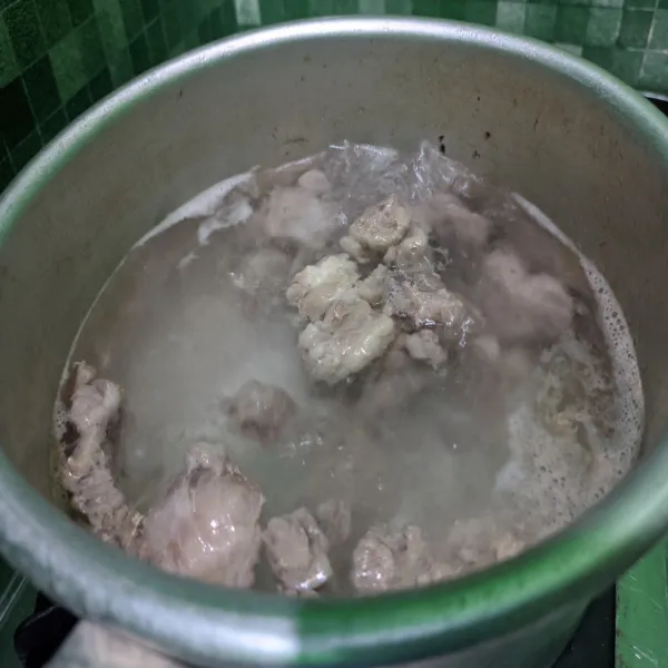 Rebus daging yang telah dipotong dadu. 
Buang air rebusan pertama, tambahkan kembali air untuk kuah secukupnya, rebus kembali hingga mendidih.