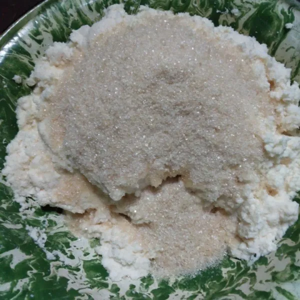 Campur singkong parut, kepala parut, garam, dan gula pasir, lalu aduk hingga tercampur rata.