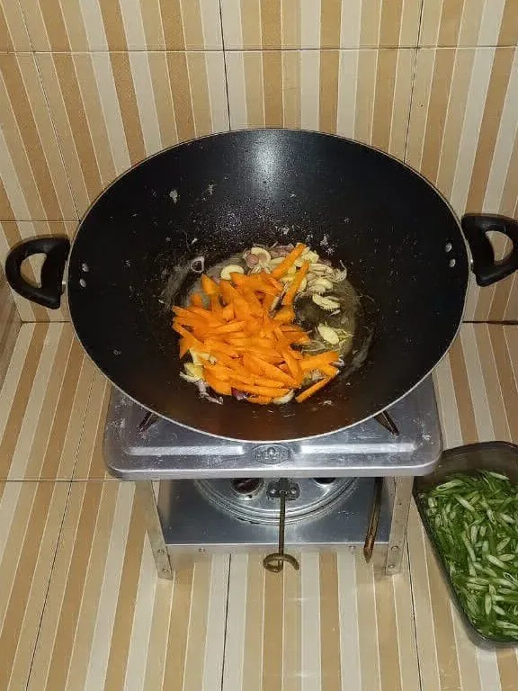 Panaskan minyak goreng lalu tumis bawang merah dan bawang putih hingga harum kemudian tambahkan wortel, aduk hingga setengah layu.