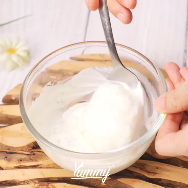 Tuangkan yogurt ke dalam wadah, tambahkan bawang putih, dan daun parsley. Kemudian aduk menggunakan sendok hingga tercampur rata.