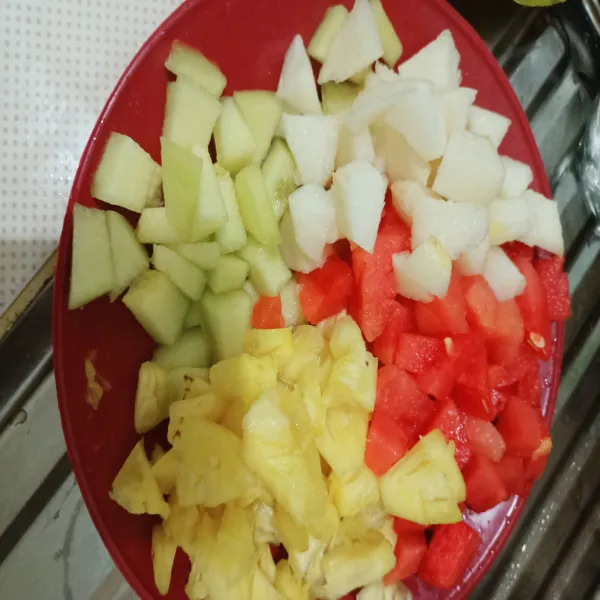 Potong dadu buah semangka, melon, pir dan nanas.