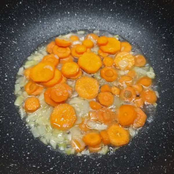 Masukkan wortel dan sedikit air, masak sampai wortel ½ matang.