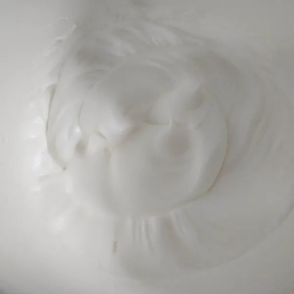 Mixer putih telur hingga mengembang, lalu masukkan gula pasir secukupnya bertahap. Miixer hingga soft peak.