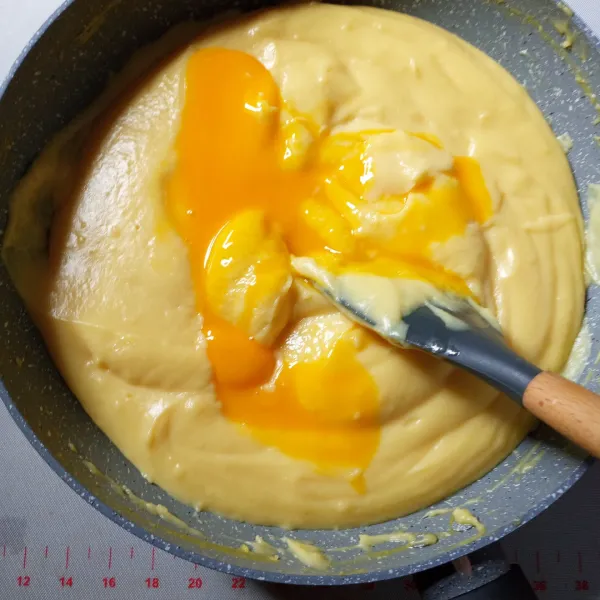 Masukkan mentega, aduk sampai rata. 
Setelah hangat kuku masukkan kuning telur bertahap, aduk sampi benar-benar menyatu.