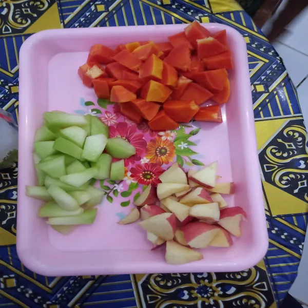 Potong kotak buah pepaya, buah apel dan buah melon.