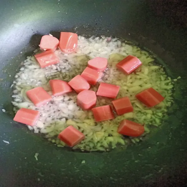 Tumis bawang putih cincang dan bawang merah cincang hingga harum lalu goreng sosis yang sudah dipotong hingga matang