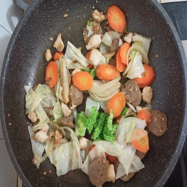 Tambahkan ayam dan bakso lalu disusul dengan wortel dan kol.