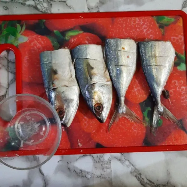Bersikan ikan kembung. Potong ikan menjadi dua bagian. Marinasi ikan dengan bahan marinasi.