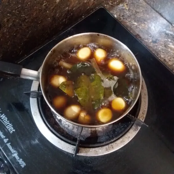 Didihkan air, masukkan telur puyuh, gula merah, daun jeruk, daun salam, serai, kaldu jamur, ketumbar bubuk, garam, kecap manis, aduk rata, masak hingga mendidih dan bumbu meresap ke telur.
