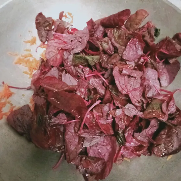 Masukkan bayam merah aduk rata, tambahkan garam, kaldu bubuk dan lada bubuk, masak hingga layu.