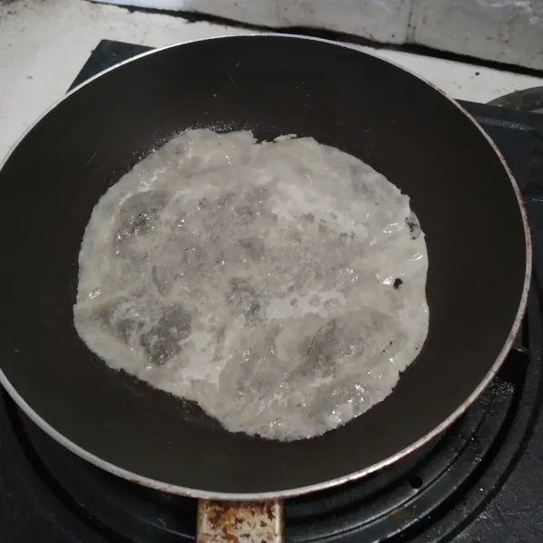 Panaskan 2 sdm minyak goreng di teflon, lalu letakkan kulit lumpia di atasnya.