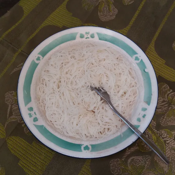Tiriskan bihun, tuang minyak wijen, aduk rata, & sisihkan.