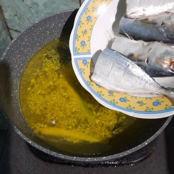 Setelah mendidih masukan ikan kembung, masak sampai matang. Balik sekali saja agar ikan tidak hancur.