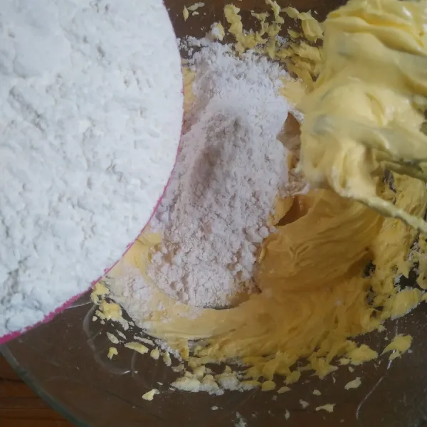Tambahkan tepung maizena, tepung terigu dan susu bubuk secara bertahap. 
Aduk menggunakan spatula.