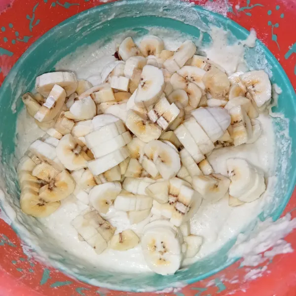 Kupas pisang dan potong-potong kecil, lalu masukkan ke dalam adonan dan aduk rata.