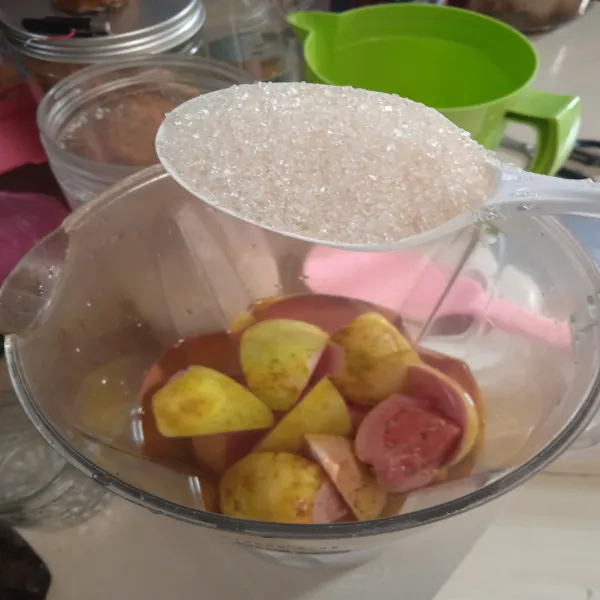Siapkan gelas blender, masukkan potongan jambu, tambahkan secukupnya air dan gula.