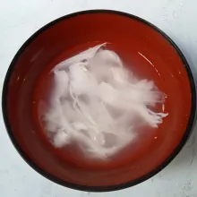 Kupas kelapa muda dan ambil airnya beserta daging buahnya.