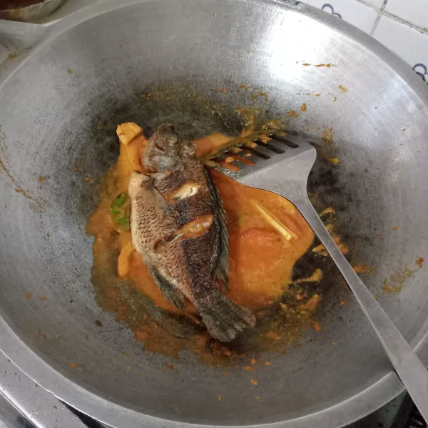 Masukkan ikan nila yang sudah digoreng, aduk rata.