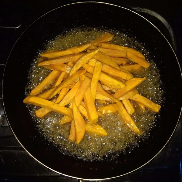 Masukkan ubi goreng ke dalam karamel, lalu aduk sampai ubi terbalur rata dengan karamel. Kemudian angkat dan sajikan.