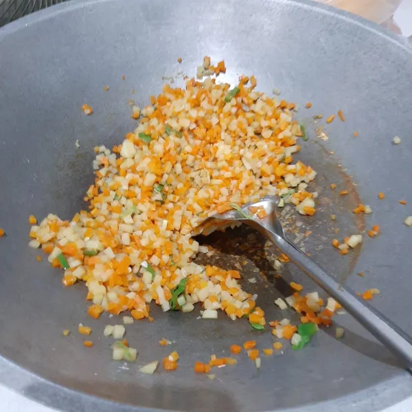Tumis bawang putih halus, lalu tambahkan sedikit air. Masukkan wortel, kentang, daun bawang, seledri, garam, dan kaldu bubuk. Masak hingga isian matang.