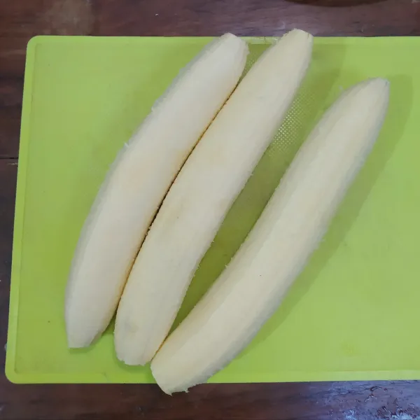 Pilih pisang yang matangnya pas, jangan yang terlalu matang lalu kupas pisang.