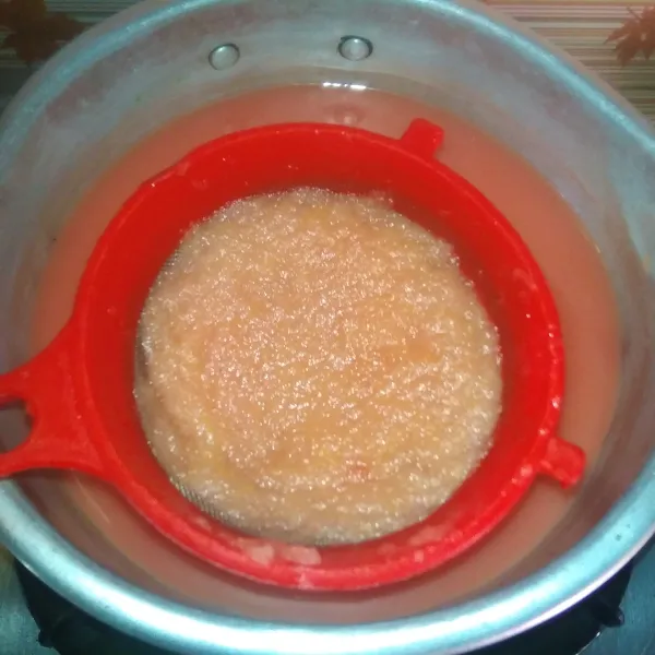 Siapkan sauce pan, tuang jus semangka ke dalamnya sambil saring untuk diambil sarinya saja.