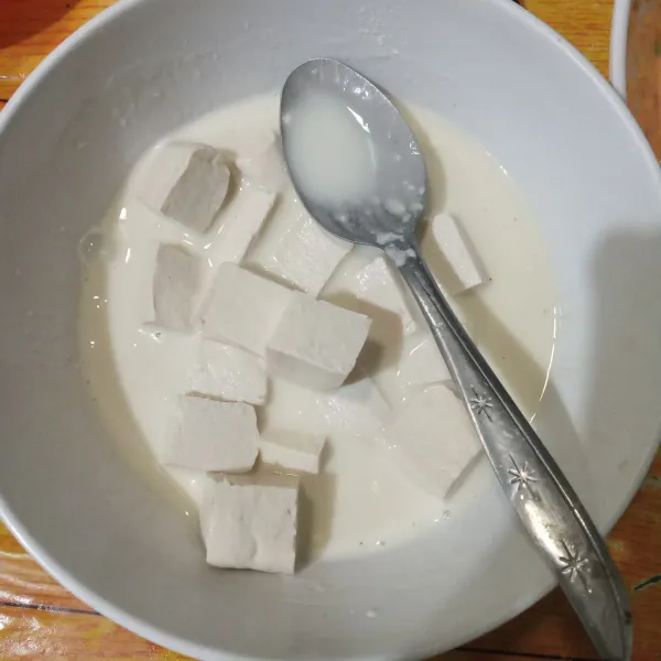 Masukkan potongan tahu ke dalam adonan tepung.