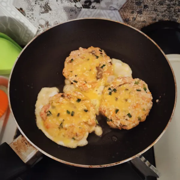 Panaskan pan, beri minyak goreng, lalu celupkan wanjajeon ke telur. Kemudian goreng hingga kedua sisi kecokelatan.