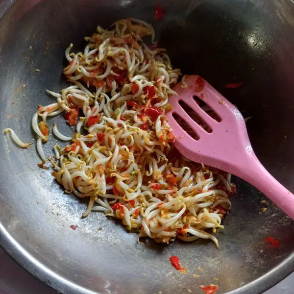 Masukkan taoge, aduk merata dan bumbui dengan garam, gula, kaldu bubuk, merica bubuk.
Setelah taoge mulai layu, matikan api lalu sisihkan dahulu.