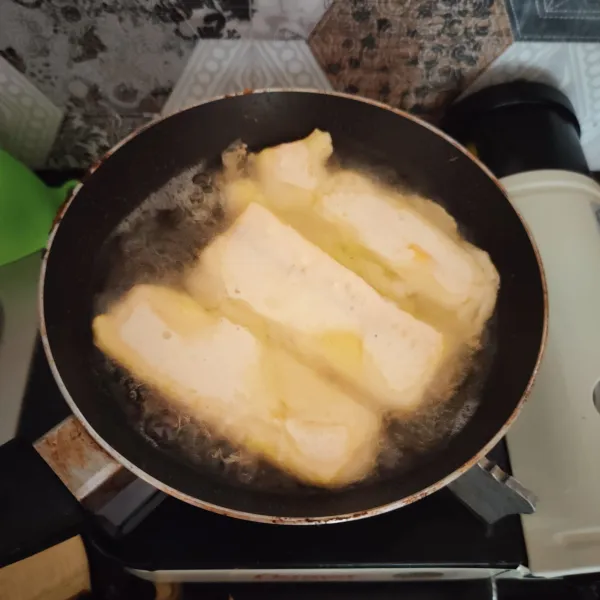 Celupkan pisang ke adonan, kemudian goreng hingga garing.