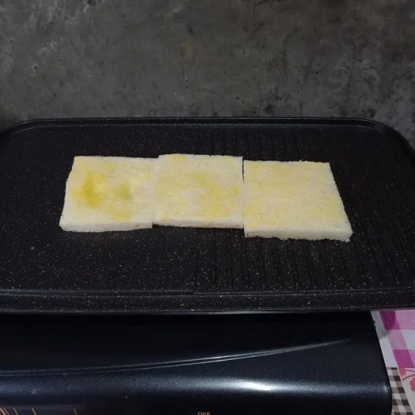 Olesi dua sisi roti dengan margarin. 
Panggang dengan api kecil. 
Kemudian balikkan.