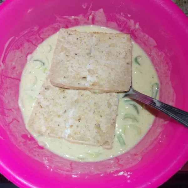 Celupkan tempe menjes ke dalam adonan basah sampai terbalur seluruh bagian tempe menjes.