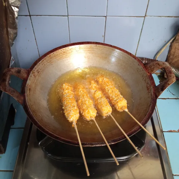 Goreng corn stik hingga kuning keemasan, lalu angkat dan sajikan dengan saus sambal serta mayonaise.